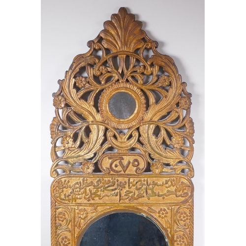 1061 - An Ottoman carved giltwood wall mirror with Islamic script and Hijri date decoration, 37 x 84cm