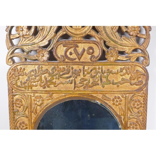 1061 - An Ottoman carved giltwood wall mirror with Islamic script and Hijri date decoration, 37 x 84cm