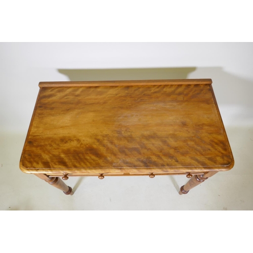 1070 - A satin birch two drawer writing table raised on turned tapered supports, 91 x 48cm, 75cm high