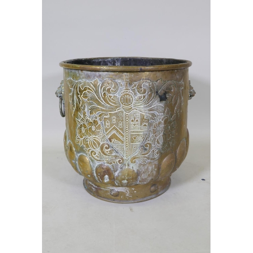 1071 - A C19th brass peat bucket with two lion mask handles, a gadrooned base and repousse heraldic decorat... 