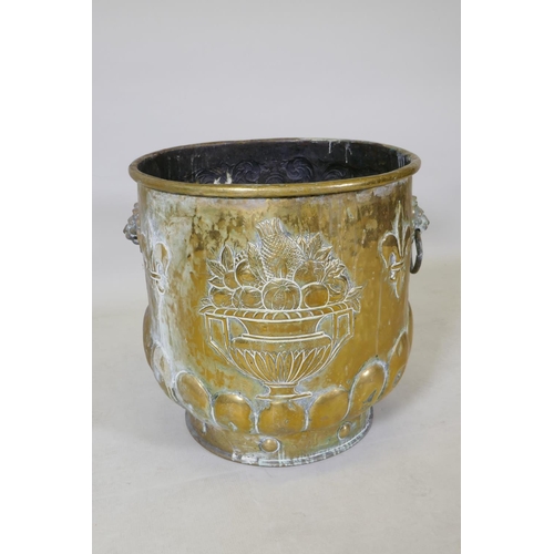 1071 - A C19th brass peat bucket with two lion mask handles, a gadrooned base and repousse heraldic decorat... 