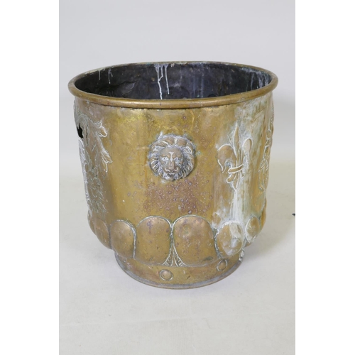 1071 - A C19th brass peat bucket with two lion mask handles, a gadrooned base and repousse heraldic decorat... 