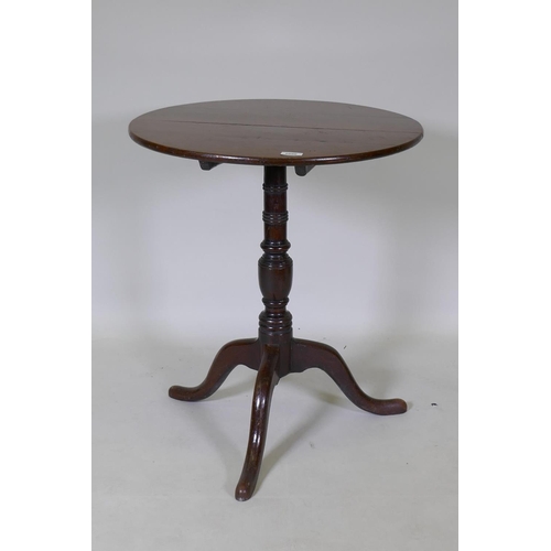 1096 - A Georgian tilt top oak table, raised on a canon barrel turned column with tripod supports, adapted,... 