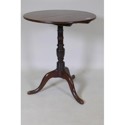 1096 - A Georgian tilt top oak table, raised on a canon barrel turned column with tripod supports, adapted,... 