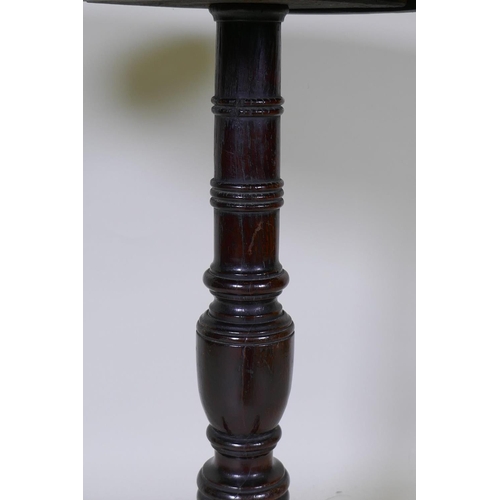 1096 - A Georgian tilt top oak table, raised on a canon barrel turned column with tripod supports, adapted,... 