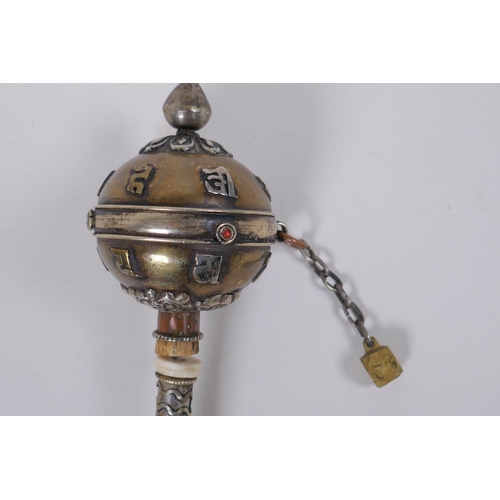 123 - A Tibetan bronze and silvered metal prayer wheel with raised script decoration, 22cm