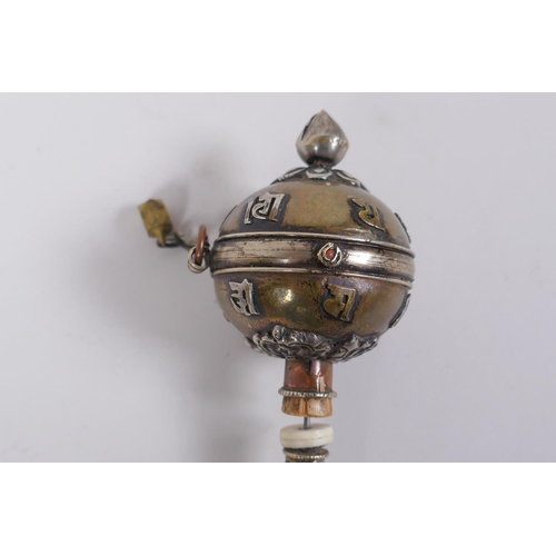 123 - A Tibetan bronze and silvered metal prayer wheel with raised script decoration, 22cm