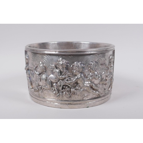 129 - A silvered composition pot with raised putti decoration, 20cm diameter