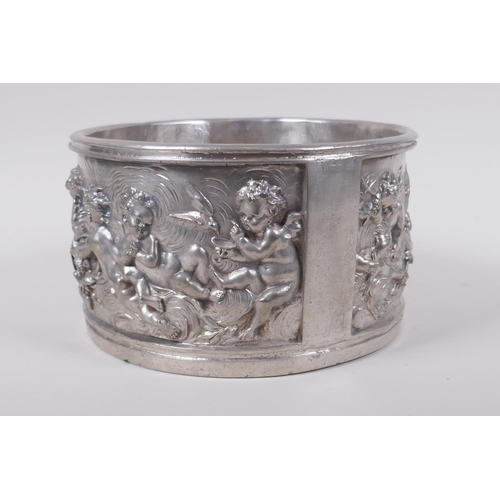 129 - A silvered composition pot with raised putti decoration, 20cm diameter