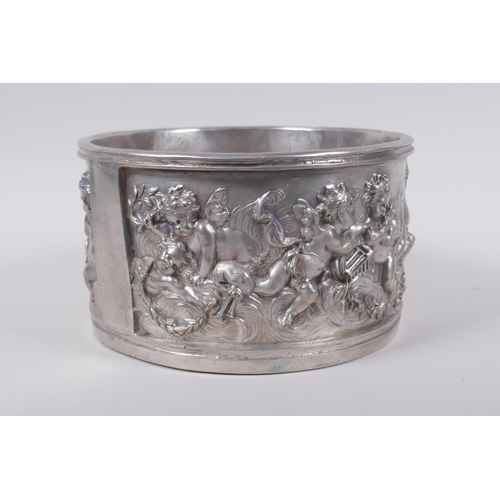 129 - A silvered composition pot with raised putti decoration, 20cm diameter