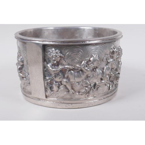 129 - A silvered composition pot with raised putti decoration, 20cm diameter