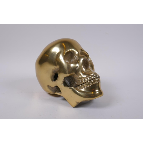 132 - A decorative cast gilt metal skull, 14 cm high