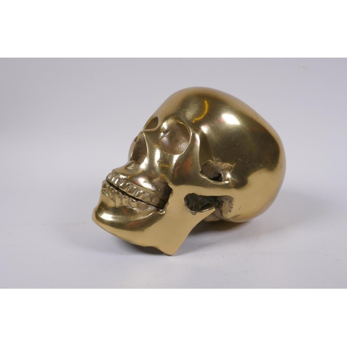 132 - A decorative cast gilt metal skull, 14 cm high