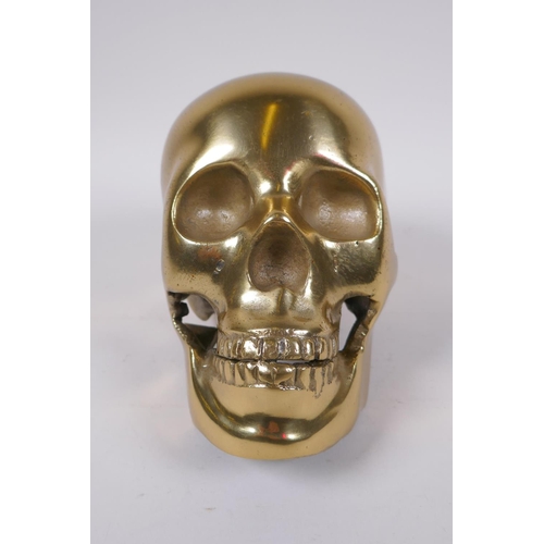 132 - A decorative cast gilt metal skull, 14 cm high