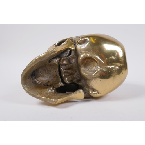 132 - A decorative cast gilt metal skull, 14 cm high