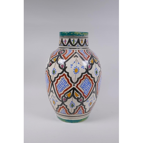 134 - A North African hand painted terracotta vase, signed to the base, 34cm high