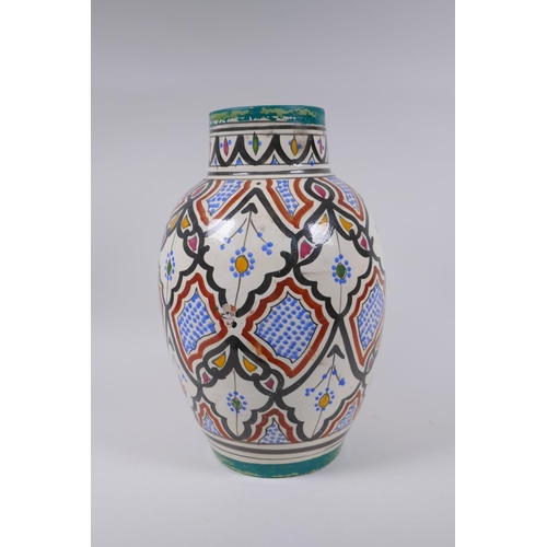 134 - A North African hand painted terracotta vase, signed to the base, 34cm high