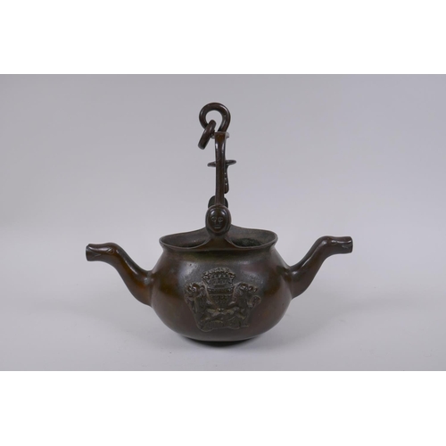 137 - A solid bronze double spouted hanging tea pot with heraldic decoration, 29cm long