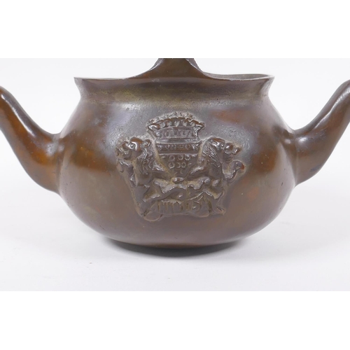 137 - A solid bronze double spouted hanging tea pot with heraldic decoration, 29cm long