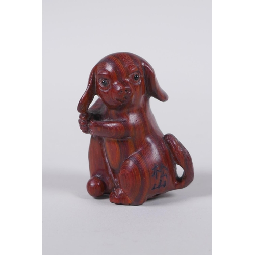 138 - A Japanese carved wood netsuke in the form of a dog, signed, 5cm high