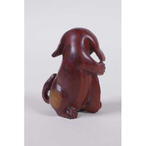 138 - A Japanese carved wood netsuke in the form of a dog, signed, 5cm high