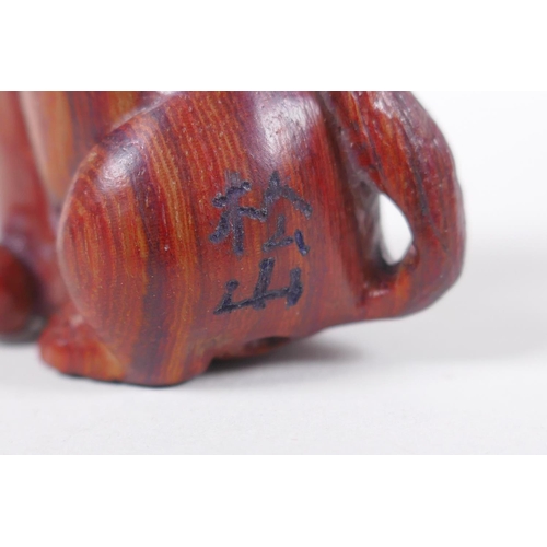 138 - A Japanese carved wood netsuke in the form of a dog, signed, 5cm high