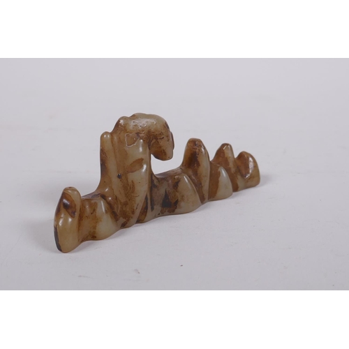 150 - A C19th Chinese celadon jade brush rest carved in the form of a rock formation, 11cm long