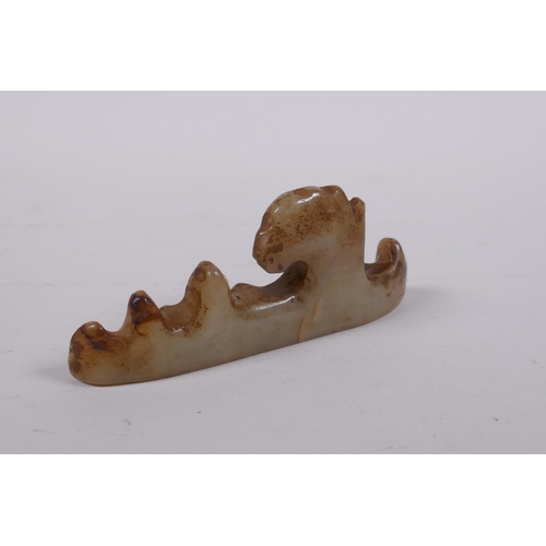 150 - A C19th Chinese celadon jade brush rest carved in the form of a rock formation, 11cm long