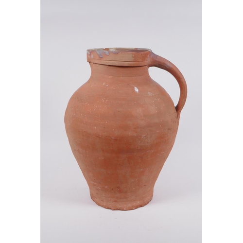 154 - An antique terracotta jug, AF chips