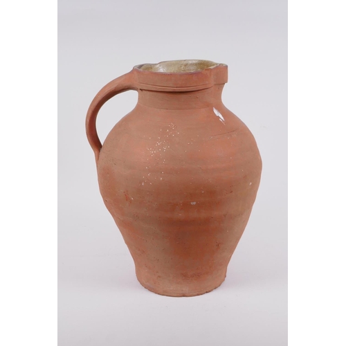 154 - An antique terracotta jug, AF chips