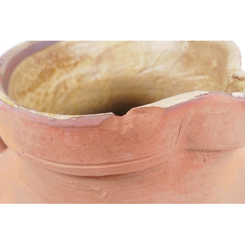 154 - An antique terracotta jug, AF chips