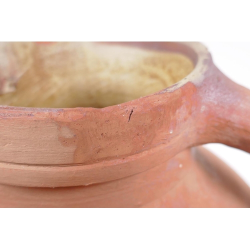 154 - An antique terracotta jug, AF chips