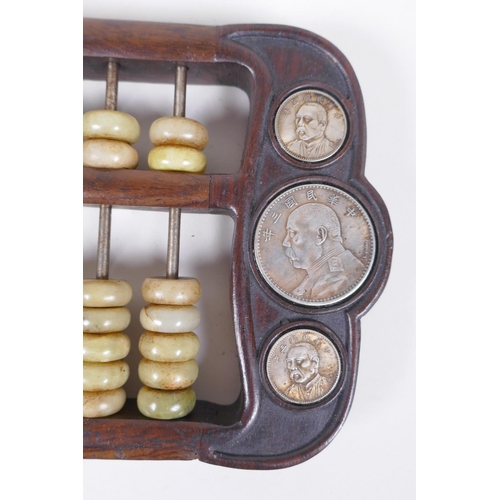 170 - A Chinese hardwood abacus with celadon hardstone counters and inset with facsimile white metal coins... 