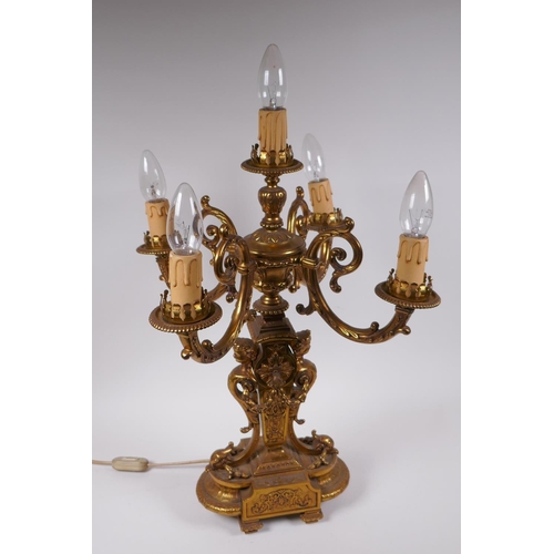 174 - A gilt bronze four branch candelabra decorated with cherubic busts and swags, 56cm high