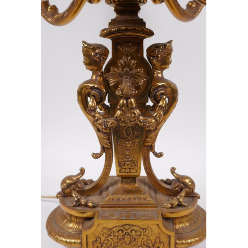 174 - A gilt bronze four branch candelabra decorated with cherubic busts and swags, 56cm high