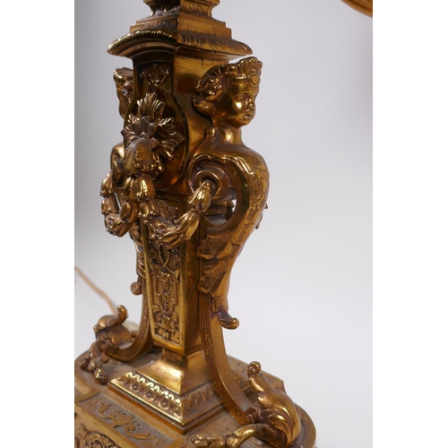 174 - A gilt bronze four branch candelabra decorated with cherubic busts and swags, 56cm high