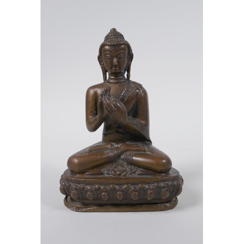 176 - A Sino Tibetan filled bronze figure of Buddha seated on a lotus throne, mark to base, 14cm high