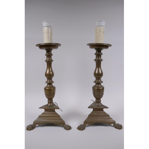 17 - A pair of antique bronze candlesticks, converted to electricity, 43cm high