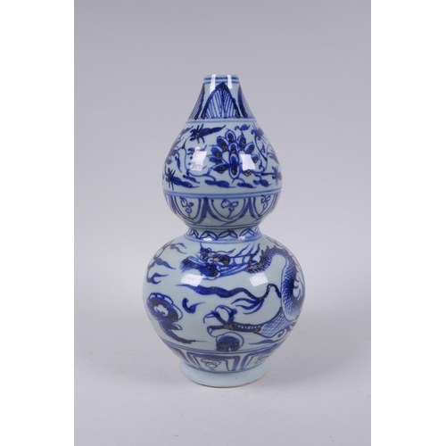 178 - A Chinese blue and white porcelain double gourd vase with dragon and flower decoration, 26cm high