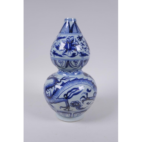 178 - A Chinese blue and white porcelain double gourd vase with dragon and flower decoration, 26cm high