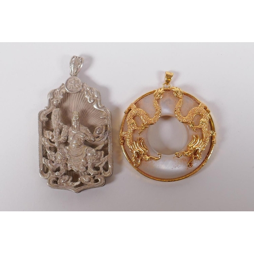 185 - A Chinese gilt metal and glass pendant with dragon decoration, and a white metal pendant with immort... 