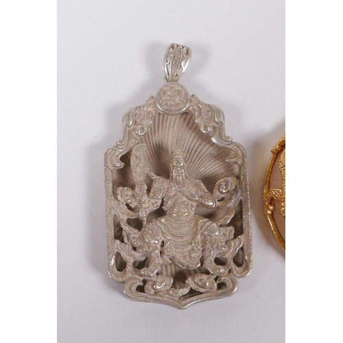 185 - A Chinese gilt metal and glass pendant with dragon decoration, and a white metal pendant with immort... 