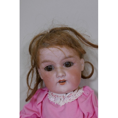 189 - An Armand Marseille Floradora porcelain head doll with rolling brown eyes and composition body, 45cm... 