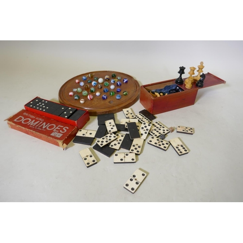 194 - An antique solitaire board with marbles and wood chess set, bone and ebony dominoes and another set