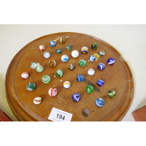 194 - An antique solitaire board with marbles and wood chess set, bone and ebony dominoes and another set