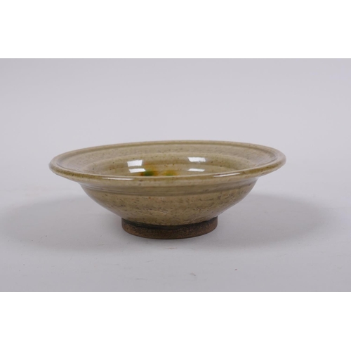 200 - A Chinese celadon glazed pottery bowl with sancai details, 11cm diameter