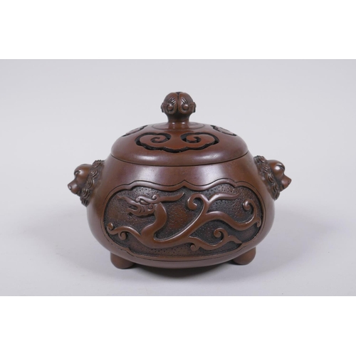 208 - A Chinese bronze censer and cover with two lion mask handles and stylised decorative dragon panels, ... 