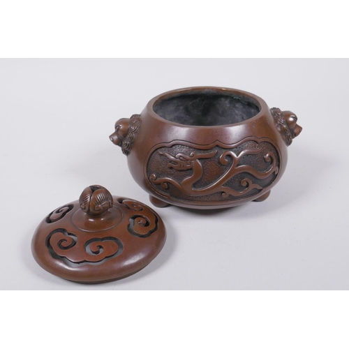 208 - A Chinese bronze censer and cover with two lion mask handles and stylised decorative dragon panels, ... 