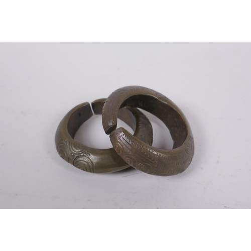 212 - An African Benin bronze bell and two bronze cash bangles, 11cm high