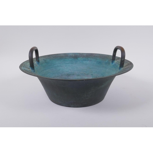 26 - An antique Chinese bronze two handled spouting bowl with dragon decoration, 30cm diameter